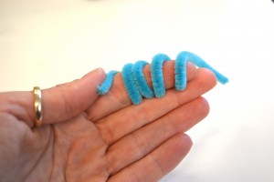 Hand with blue pipe cleaner twisted around it