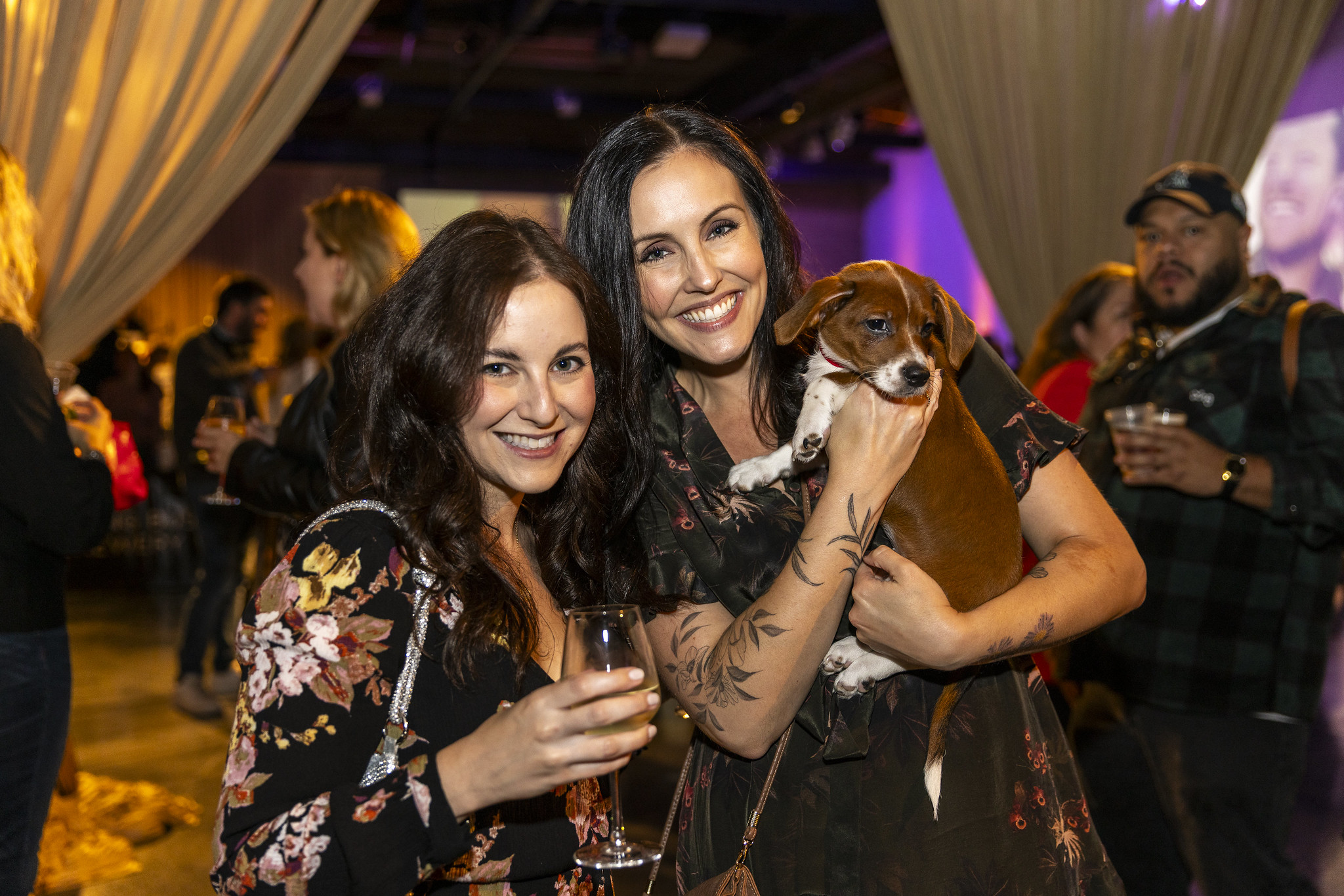 Two women at an event with a cute puppy