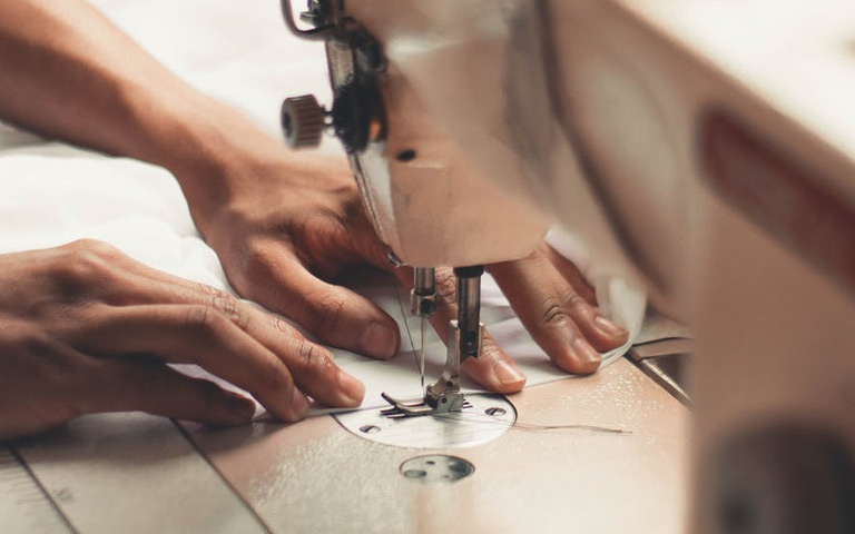 Hands use a sewing machine