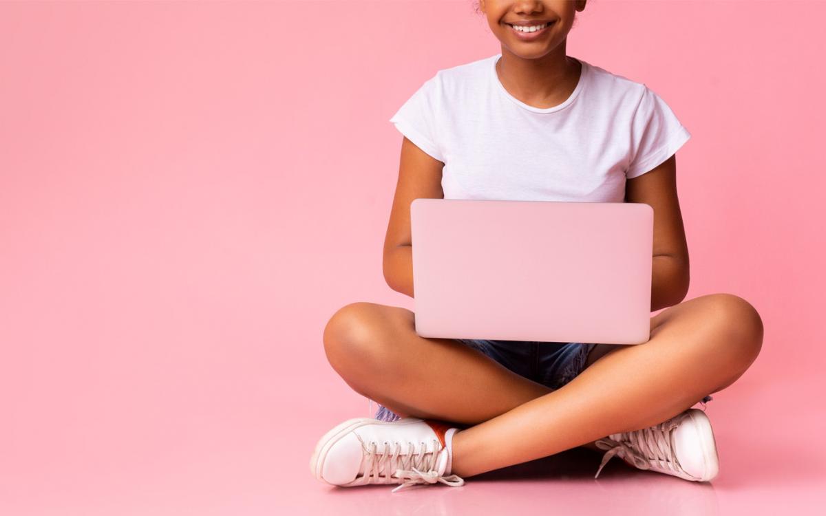 A young woman sits with a laptop