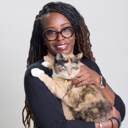 African American woman wearing glasses and a black shirt holding a cat