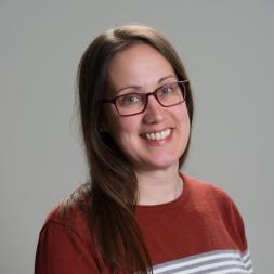 A woman with brown hair and glasses