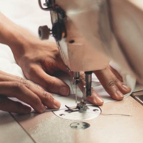 Hands use a sewing machine
