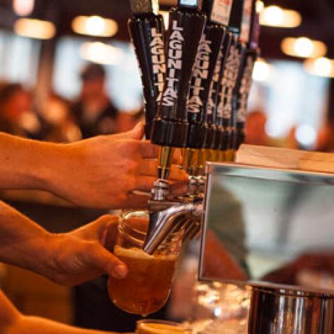 Hands pouring beer from taps
