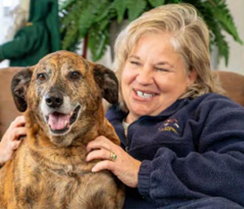 A happy woman with her healthy dog